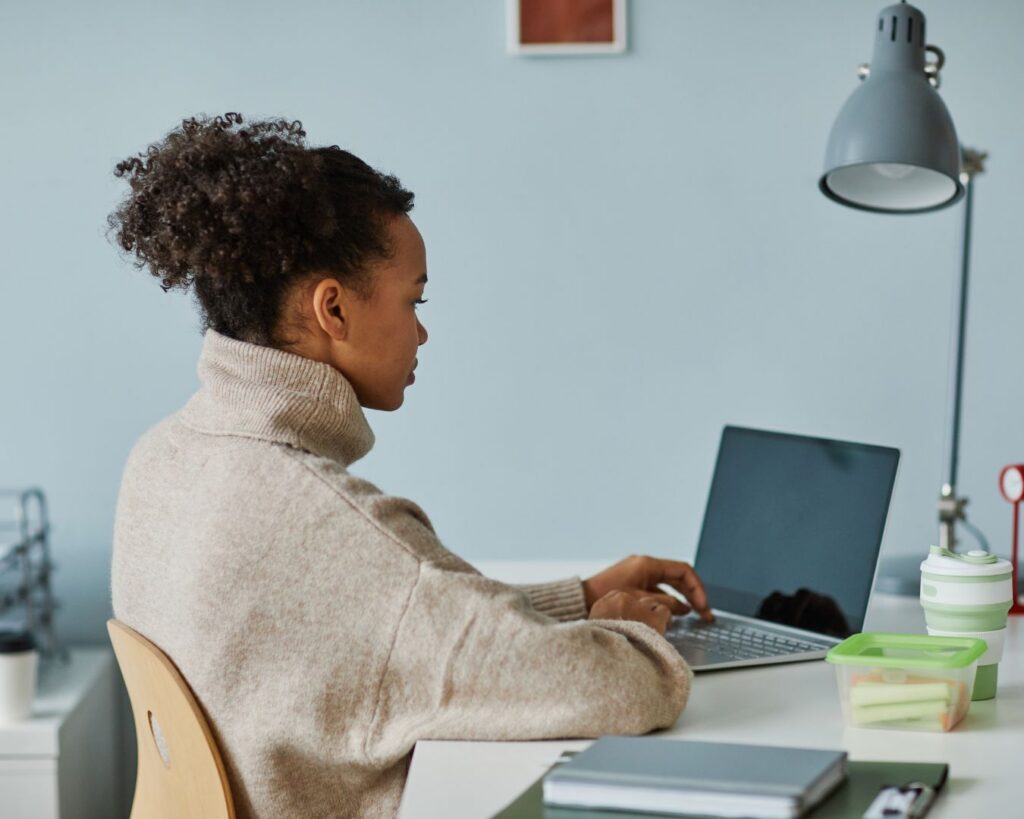 Woman working at a laptop at her desk, reflecting the balance between responsibility, availability, and personal boundaries.